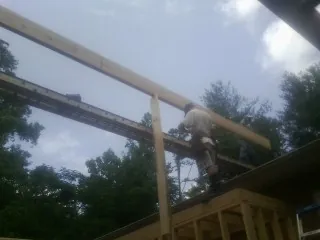 Carpenter setting a ridge beam over a new addition frame — Ice Dam Removal by Roofing Brothers in Thorsby
