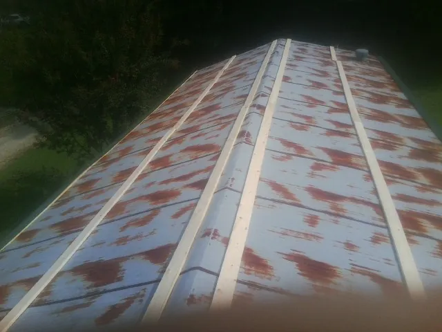 Rusted metal roof panels with new wood purlins before replacement — Storm Damage Roof Repair in Thorsby by Roofing Brothers