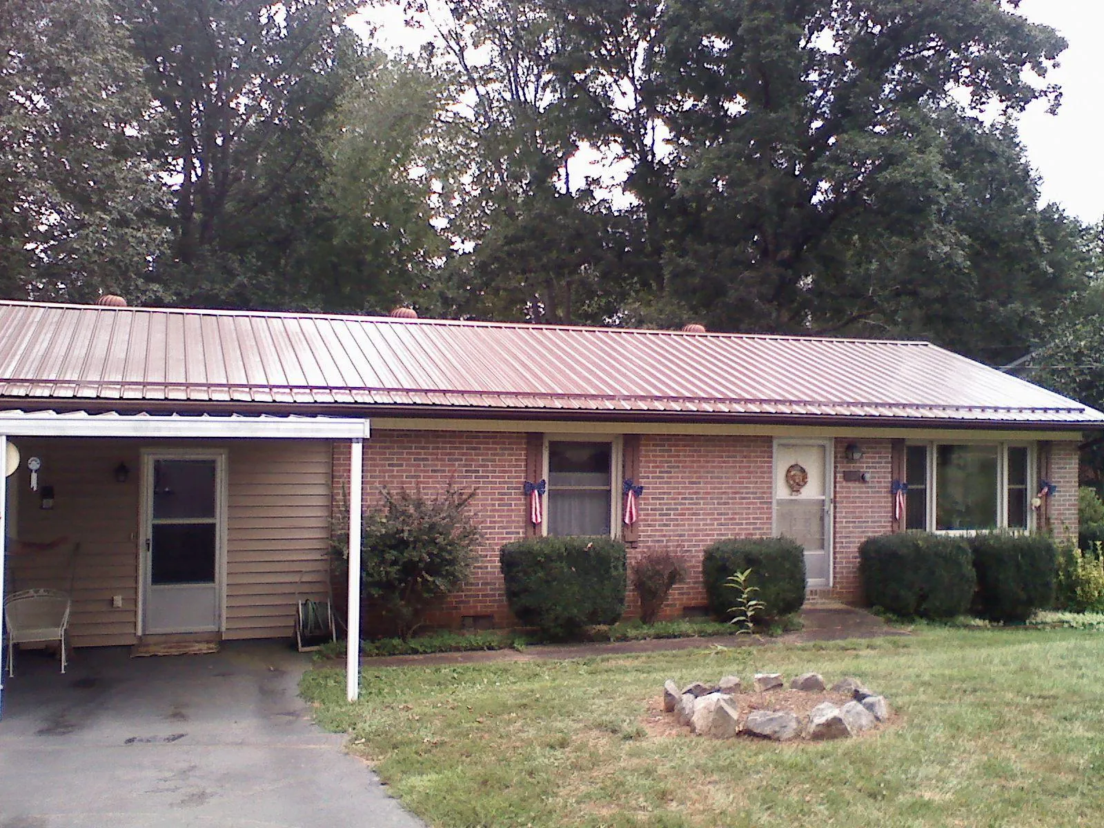 Bronze metal roof and carport on a brick ranch home — Roof Repair work by our crew in Thorsby
