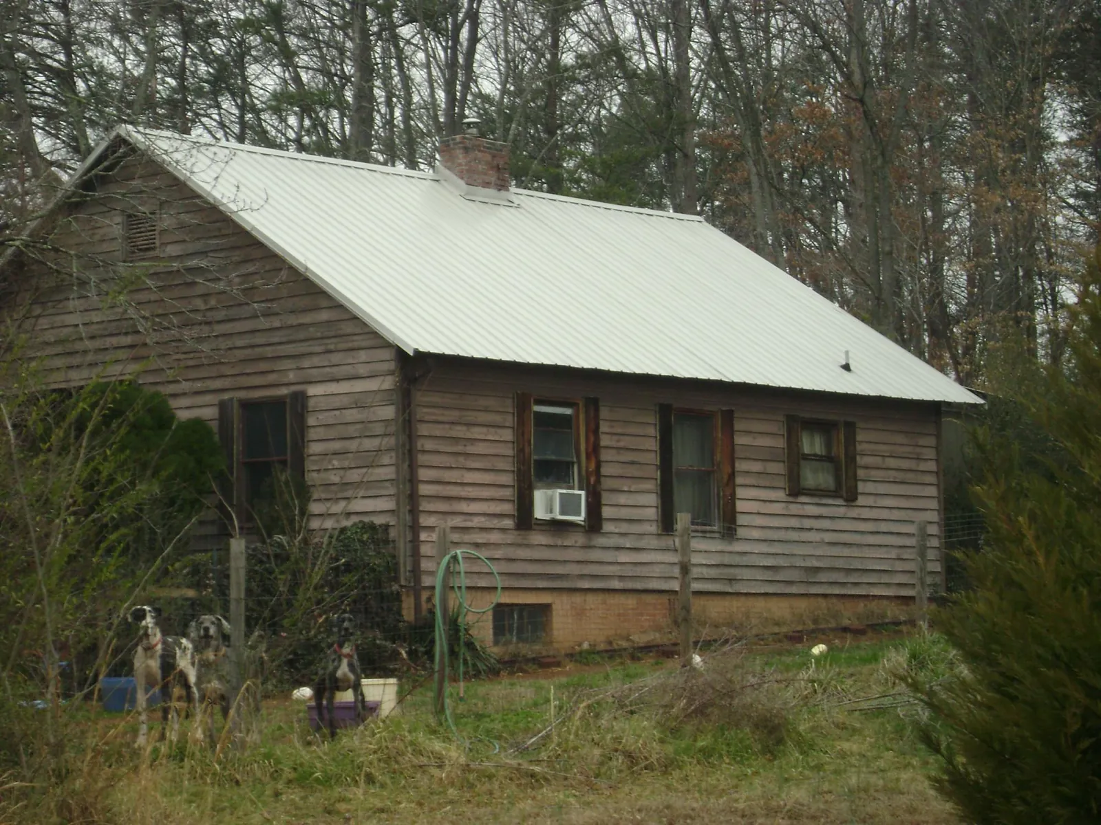 White metal roof on an old wood sided farmhouse, from a Metal Roof Installation job in Thorsby